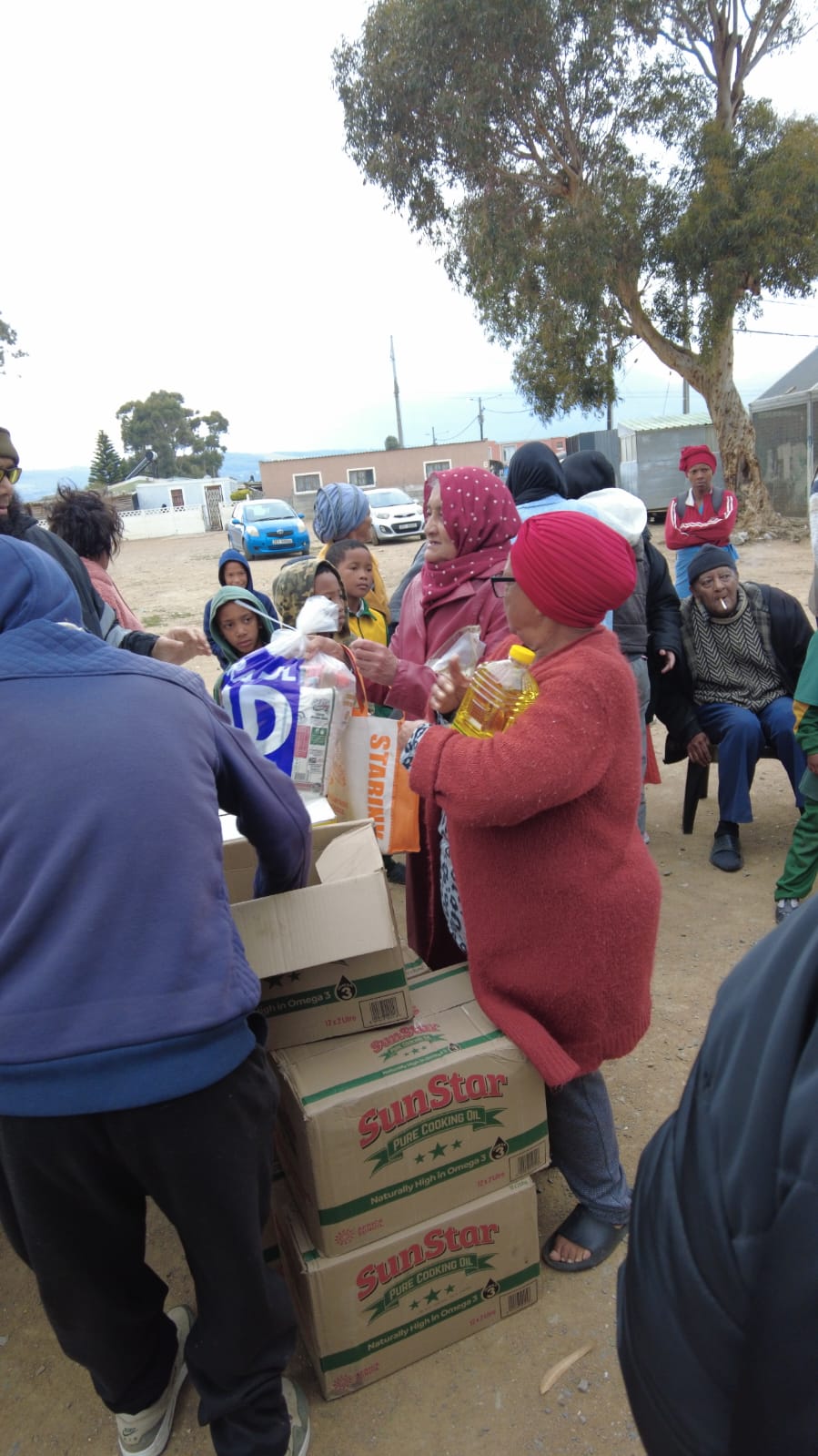 Recipients collecting food items at an outdoor distribution point